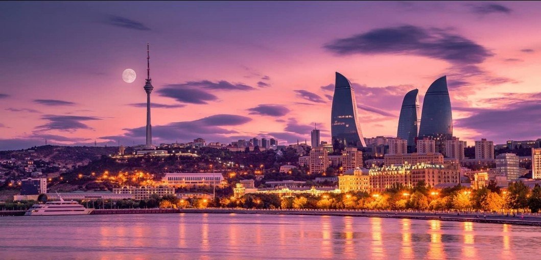 Baku skyline at dusk with the Flame Towers, TV tower, and Caspian Sea waterfront